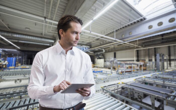 Businessman using tablet on factory shop floor