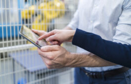 Close-up of businessman and businesswoman using tablet in modern factory