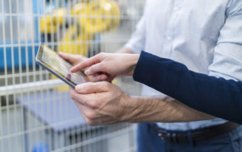 Close-up of businessman and businesswoman using tablet in modern factory