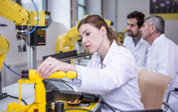 Engineers examining industrial robots